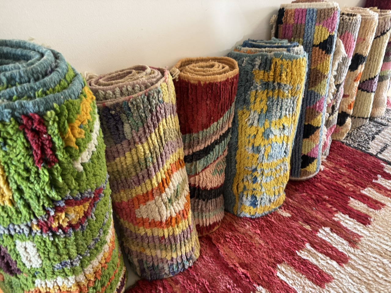 row of rolled moroccan runner rugs in bright colors